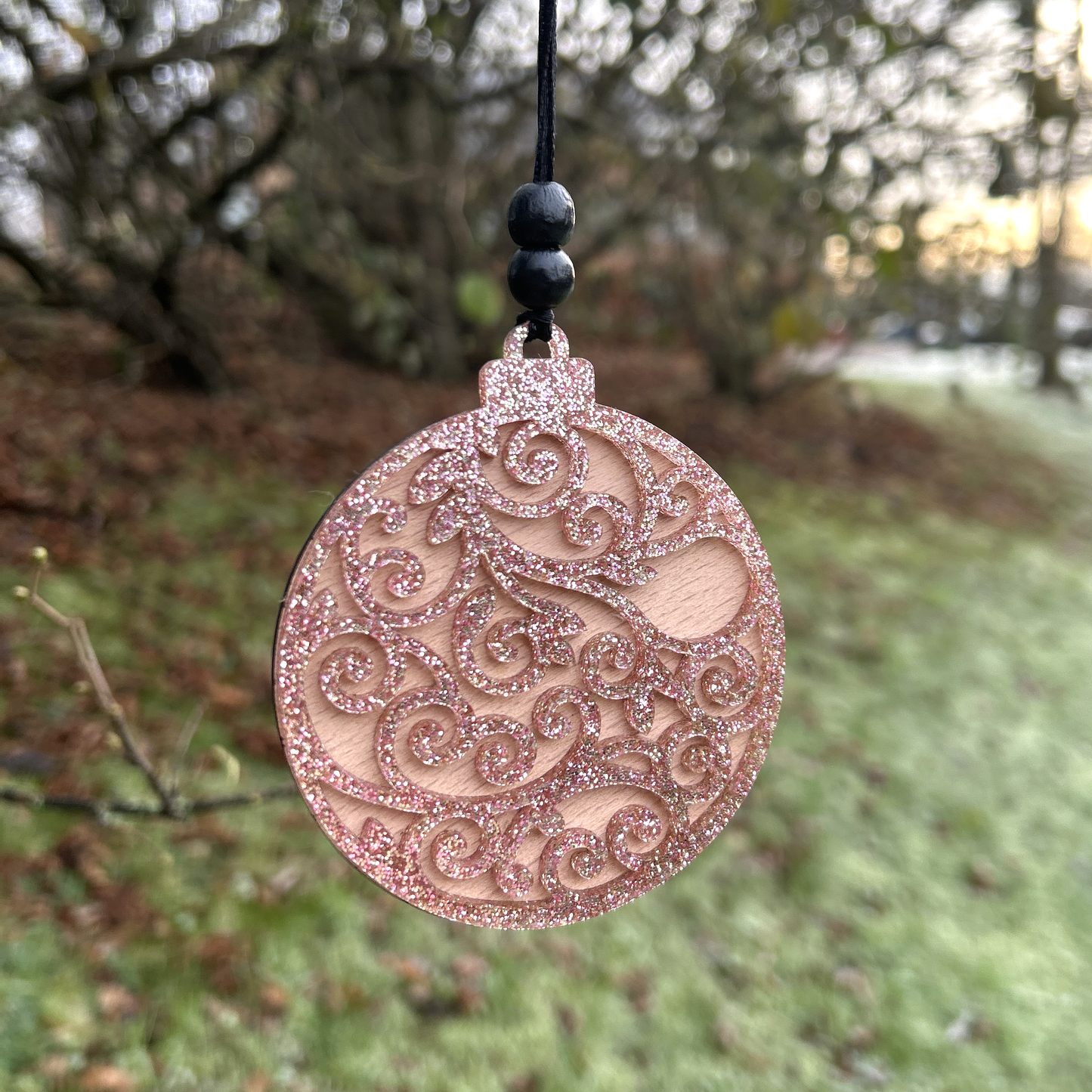 Swirly festive bauble in rose gold glitter and birch